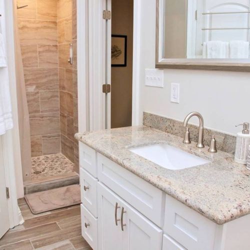Freshen up in the master bathroom w/ a sink & warm stone finishes.