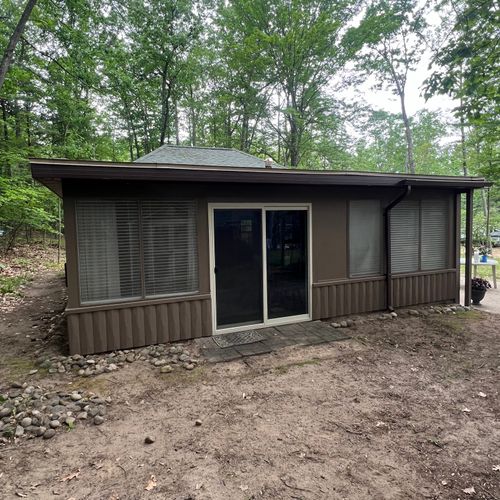 EXTERIOR:  The back of the cabin and the backyard in the summer