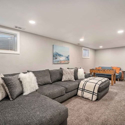 - game ready basement with foosball table, plush sectional, and soft carpeting
- thoughtfully lit with recessed lighting and natural light from two windows
- cozy yet functional space ideal for relaxing, playing, or hosting guests