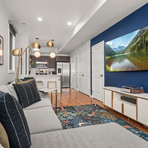 Bright open living area with smart tv, comfortable seating, and seamless dining flow