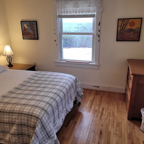 Bedroom #1 (main floor):  features a full-size bed, table, chair, dresser, and closet.