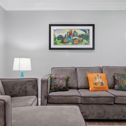 Cozy living nook w/ soft seating & cheerful artwork.