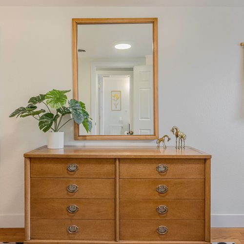 - unpack and unwind with plenty of drawer space and a full sized mirror
- catch the morning light as you get ready beside charming decor and details
- touch of greenery and gold accents brings elegance to this restful corner