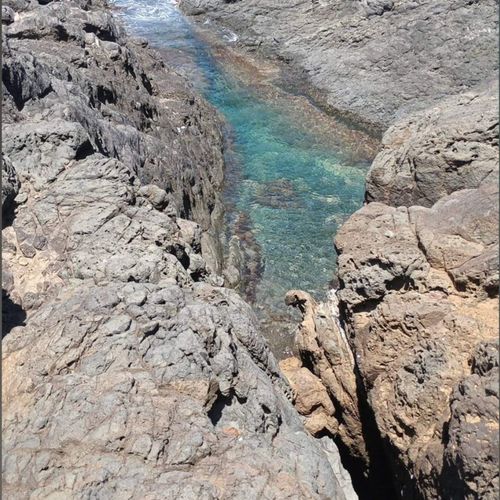 Discover a hidden gem! Crystal-clear turquoise waters wind through dramatic rock formations, leading to the open ocean.