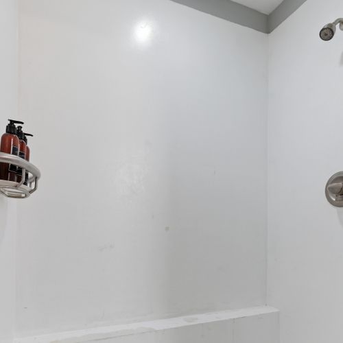 Sleek shower w/ minimalist modern finishes.