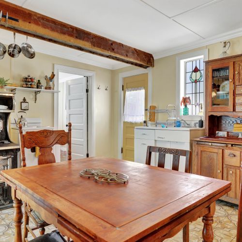 Centerpiece wooden table brings warmth and togetherness to this kitchen setting.