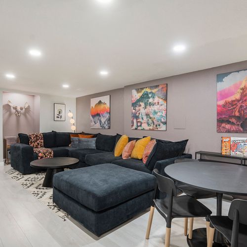 A cozy second living room, ideal for lounging, features a large tv, comfy seating, and game table.