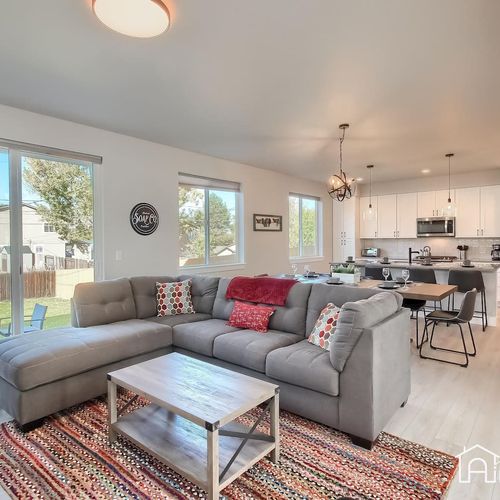 - bright and open living room with large sectional and colorful accents throughout
- dining and kitchen areas are just steps away, perfect for staying connected
- wide windows bring in natural light and views of the backyard