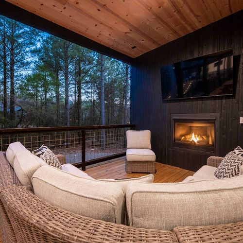 The outdoor covered patio, an oversized sectional around the fireplace.
