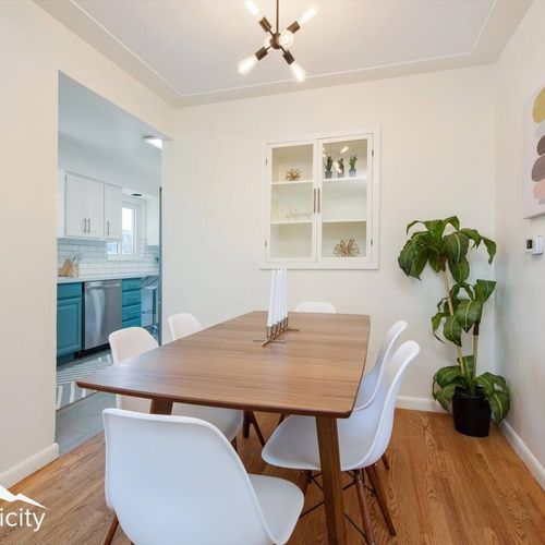- modern dining area with wood table, sleek white chairs, and minimalist lighting
- built in shelving and greenery add a fresh, stylish touch to meals
- just steps from the kitchen, it's the perfect place for shared bites and laughs