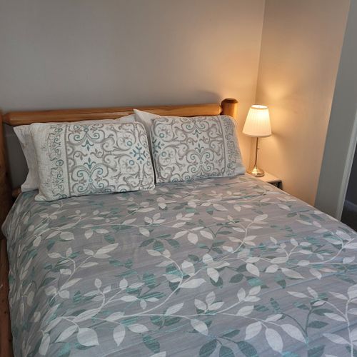 Bedroom #1:  features a queen-size bed, ceiling fan, nightstand, lamp, closet, and dresser.