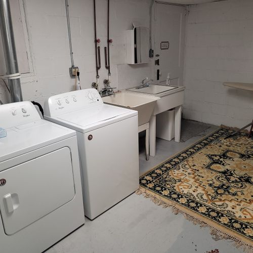 Laundry room (lower level):  the home has a large laundry room with a washer, dryer, sink, iron, and ironing board.