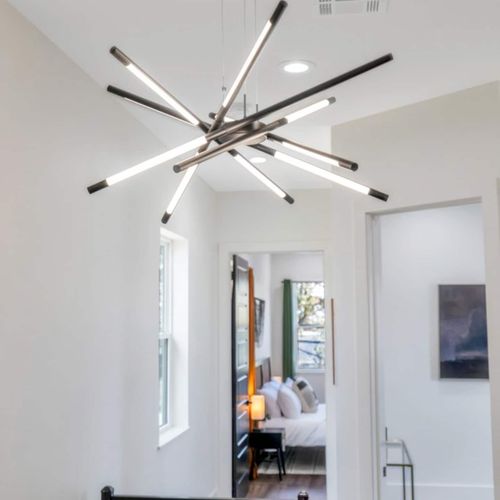 Dramatic sputnik chandelier casting a warm, sculptural glow in the hallway.