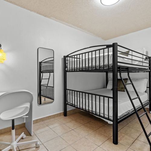 Sleek black bunk beds in a bright room offer a cozy corner for relaxation.