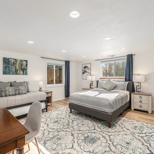 Cozy and functional, this downstairs bedroom features a comfortable bed, a versatile daybed for extra seating or sleeping, and a desk perfect for work or study.