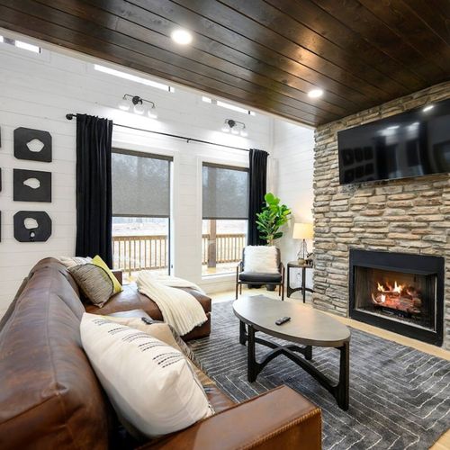 The main living room with a fireplace, tv and leather sectional!