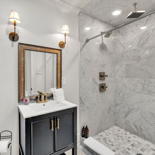 Modern bathroom with marble shower and elegant fixtures.