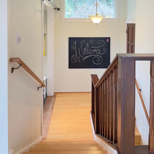 Warm and inviting stairway with natural light, hardwood floors, and a welcoming touch—an easy, comfortable transition between levels of the home.