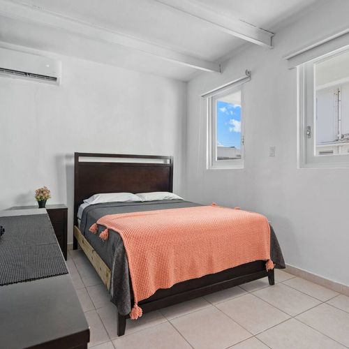 Relax luxuriously in this sophisticated bedroom adorned with contemporary artworks, harmonized by the soothing blue and white hues of the walls.