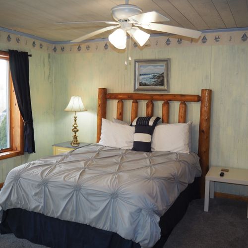 Bedroom #1 (main floor):  features a queen-size bed, private television, dresser, ceiling fan, closet, and en suite private bathroom.