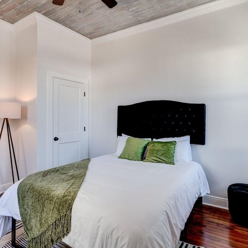 Cozy bedroom w/ a bed framed by clean white walls & natural light.