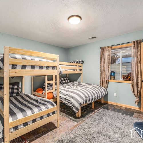 - fun and functional bunk room with two twin over full beds and cozy striped linens
- soft lighting and slate tile flooring give it a relaxed mountain lodge feel
- ideal for kids, cousins, or friends enjoying a sleepover style retreat