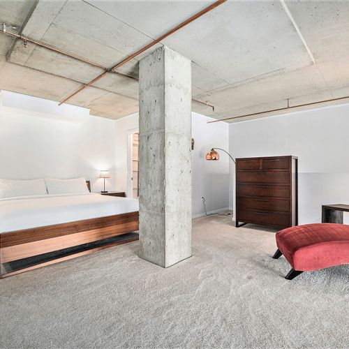 Rest easy in a stylish, industrial-inspired retreat with a plush king-size bed and soft carpeting. Warm lighting, and ample space make this bedroom your personal sanctuary for relaxation.