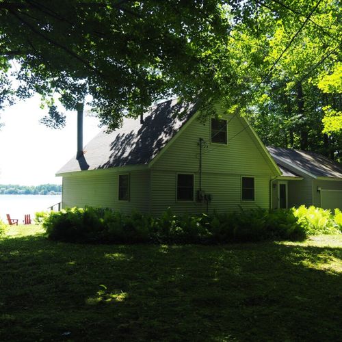 Exterior:  a broader view of the front of the cottage, with the lake in the background.