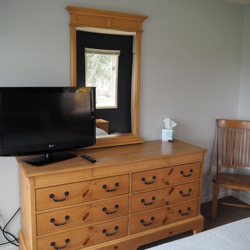 Guest bedroom:  features a queen-size bed, private entrance from the deck, nightstands with lamps, a dresser, closet, chair, and its own television.
