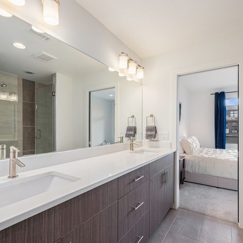 Stay fresh in this beautifully lit bathroom with double vanities, crisp white walls and plenty of space.