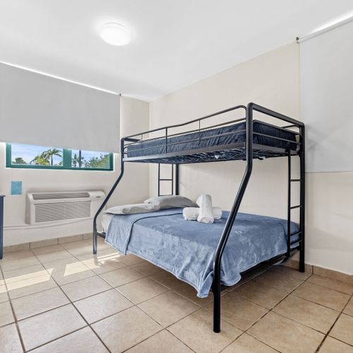 Unwind in our bright and airy bedroom, featuring a modern metal bunk bed with a full-sized bottom and single top bunk.