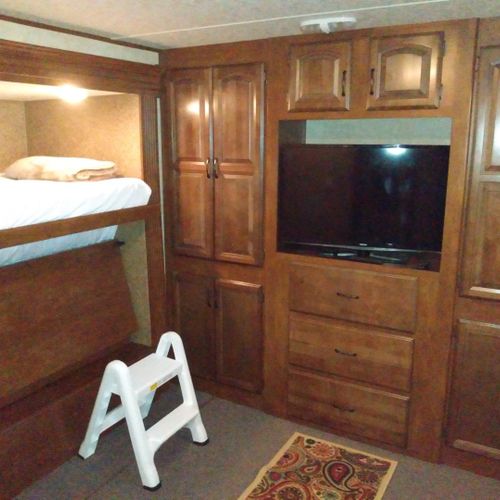 Bedroom #2:  includes 3 twin beds, a dresser, and a television.