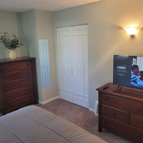Bedroom #1:  features a queen-size bed, private en suite full bathroom, private television, walk-in closet, dresser, mirror, nightstands, and lamps