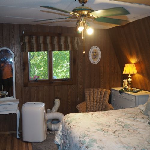 Bedroom:  includes a queen-size bed, dressers, night lamps, ceiling fan, closet, and room a/c unit.