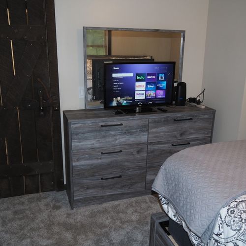 Bedroom #1 (main floor):  features a king-size bed, ceiling fan, dresser, mirror, closet, and a private television with live streaming via roku.