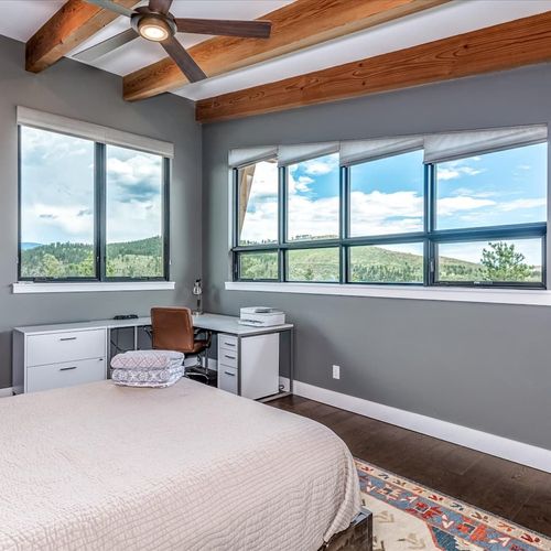 - wake up to forested hills through wide windows in this light filled corner bedroom
- dedicated desk and ceiling fan make this a serene space to work or unwind
- rustic beams and rich flooring balance comfort with elevated mountain style