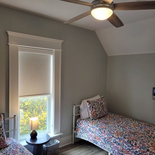 Bedroom #4 (second floor):  features a queen-size bed, twin bed, window a/c unit, ceiling fan, nightstand, lamp, dresser, and a closet.