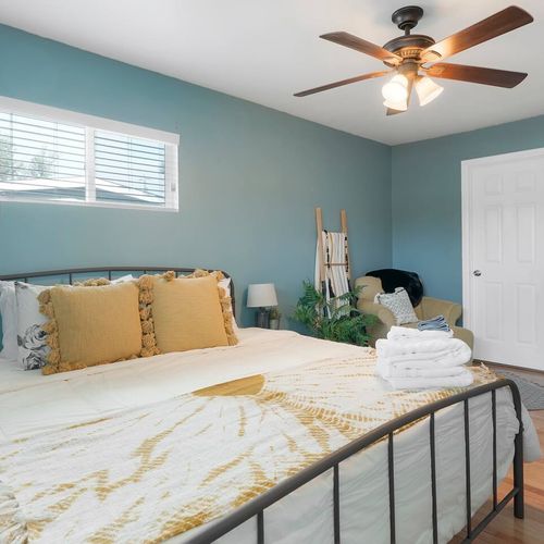 - peaceful bedroom with king bed, soothing blue walls, and warm gold accents
- ceiling fan, blackout blinds, and extra seating add comfort and function
- great retreat for restful nights and easy mornings with natural light