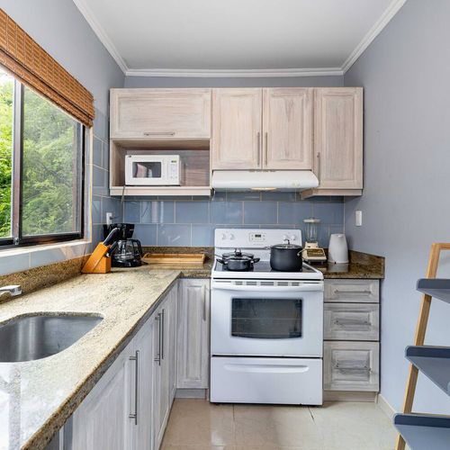 The kitchen has an electric stove with an oven, a fridge, microwave, bender and coffee maker plus all the neededequipment to cook.