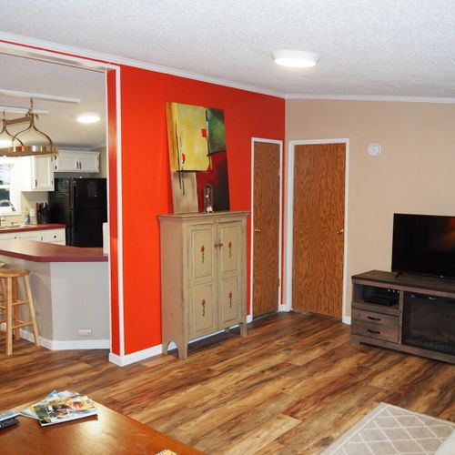 This photo shows the living room along with the door to the master bedroom (the door on the right), a closet door (the door on the left), and the entrance to the kitchen.