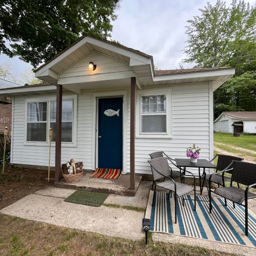 Overall:  the front of the cabin and the outdoor dining furniture