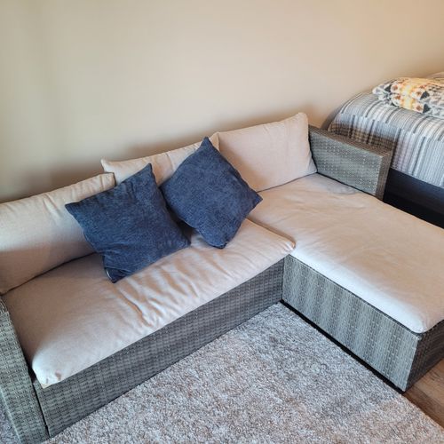 BEDROOM #1 (PRIMARY):  Features a queen-size bed, sofa bed, lakeview, private ensuite bathroom, private entrance from the back patio, private television, nightstand, lamp, ceiling fan, dresser, and shelves