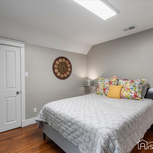 The third bedroom features a queen bed and a calming palette of natural colors, complemented by plenty of natural light from a generous window.