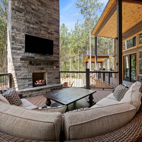 The outdoor patio has an oversized sofa around the fireplace