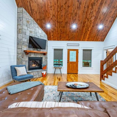 The living area features a leather sectional and an indoor fireplace!