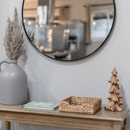 - simple yet elegant touches welcome you with natural tones and cozy textures
- round mirror reflects light and space while the soft vase and wicker tray add charm
- thoughtful decor like the rustic tree sculpture brings warmth and personality