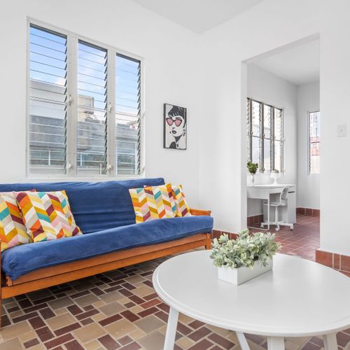 A warm living room with a view, a side table, and a painting.