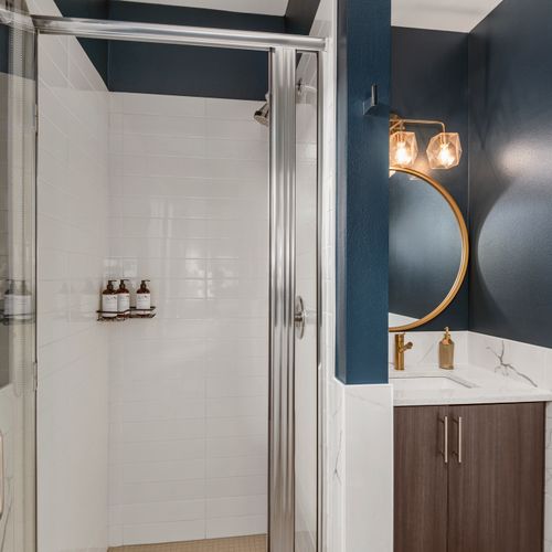 Glass shower and elegant finishes create a refreshing, hotel-inspired bathing experience.