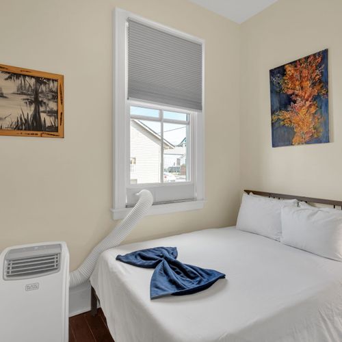 Softly styled bedroom w/ calming tones & cozy linens for a restful stay.
