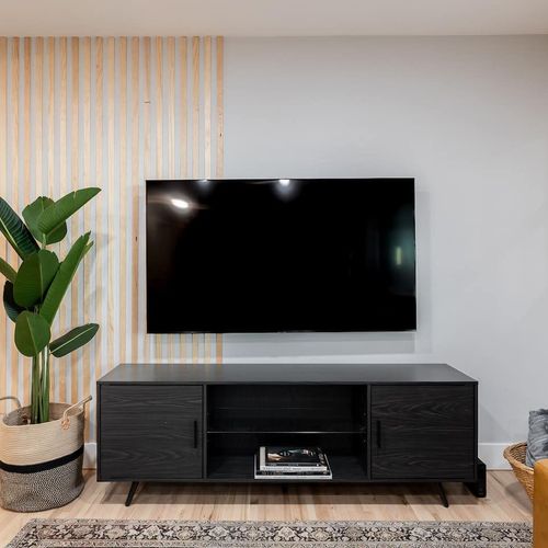 - kick back for movie night in front of a sleek flat screen tv and modern black console
- natural wood slat detailing adds warmth and charm to the entertainment space
- touch of greenery and scenic wall art make it cozy yet contemporary